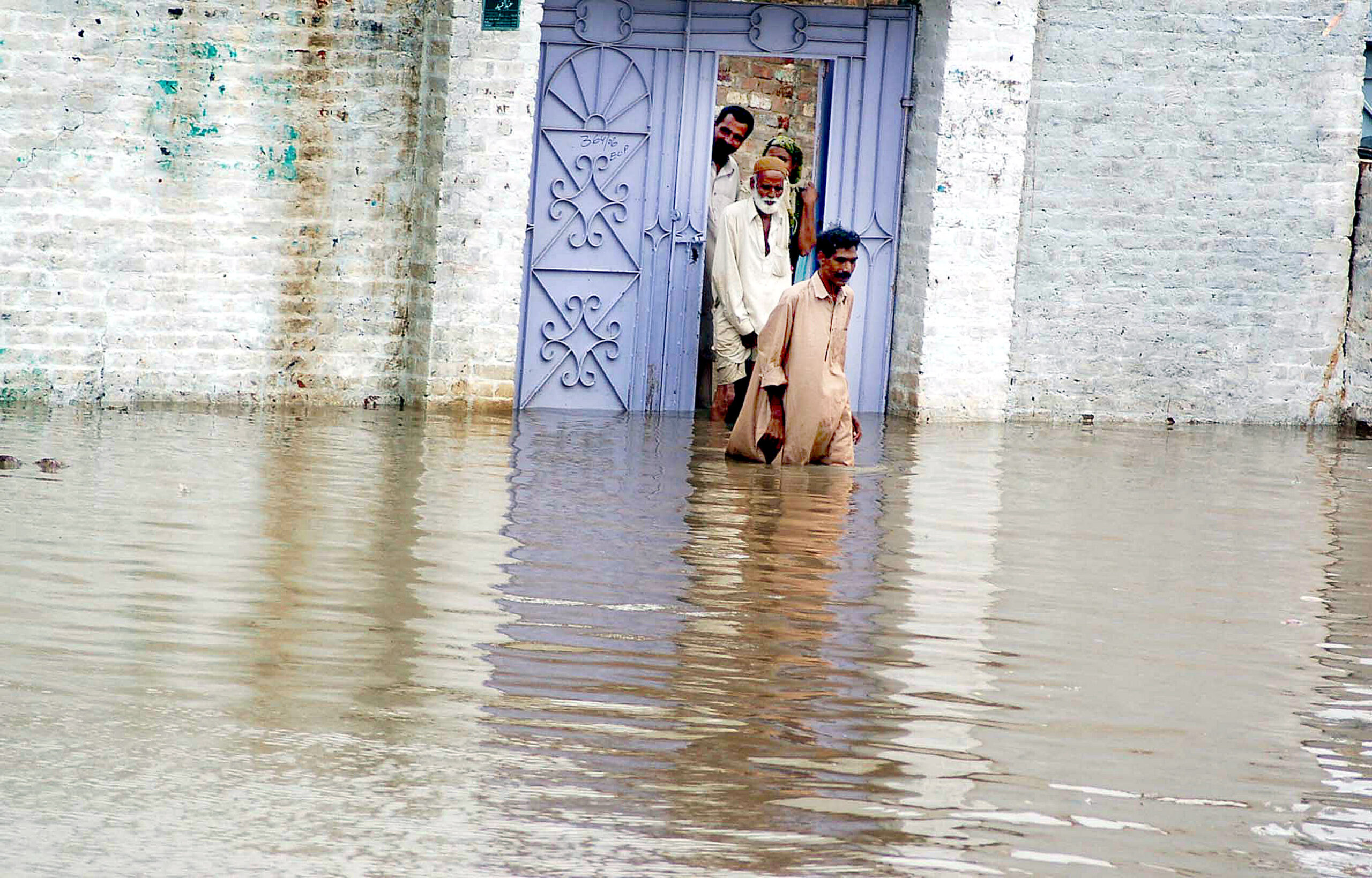 A man passes through a flooded street after heavy rains fall